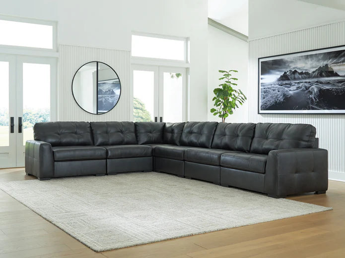 A stylish living room with a black leather sectional sofa, earthy tones, and cozy decor reflecting southeastern U.S. lifestyle.