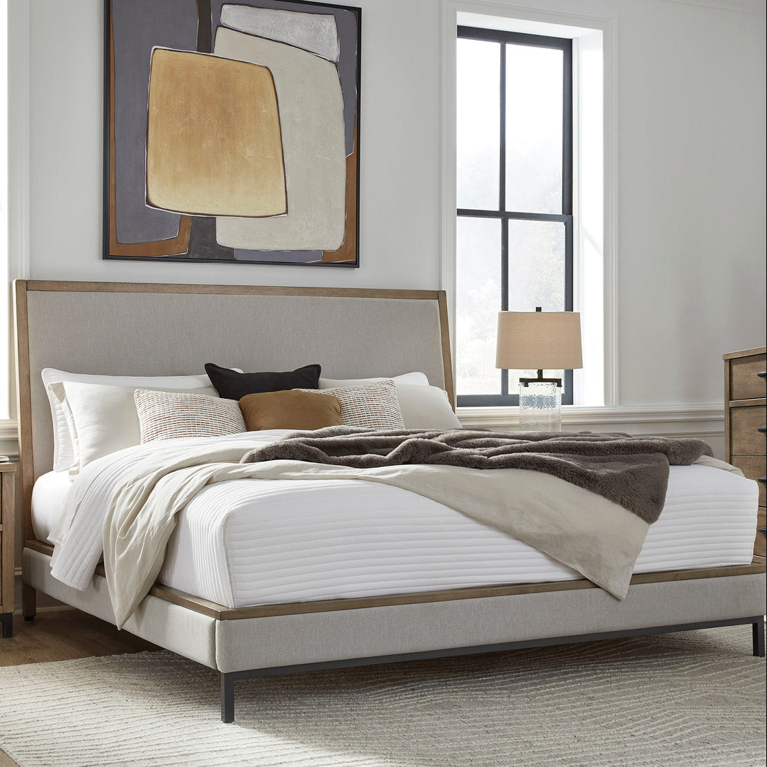 Modern bedroom with a bed, nightstands, and artwork on the wall.