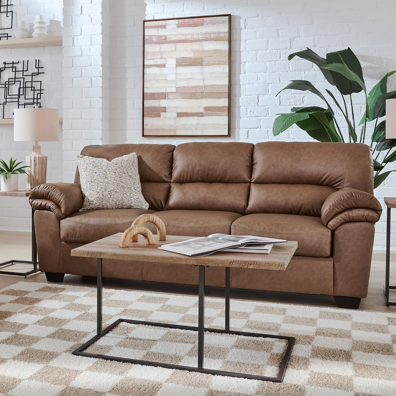Brown leather sofa in a living room with a coffee table and decorative items.